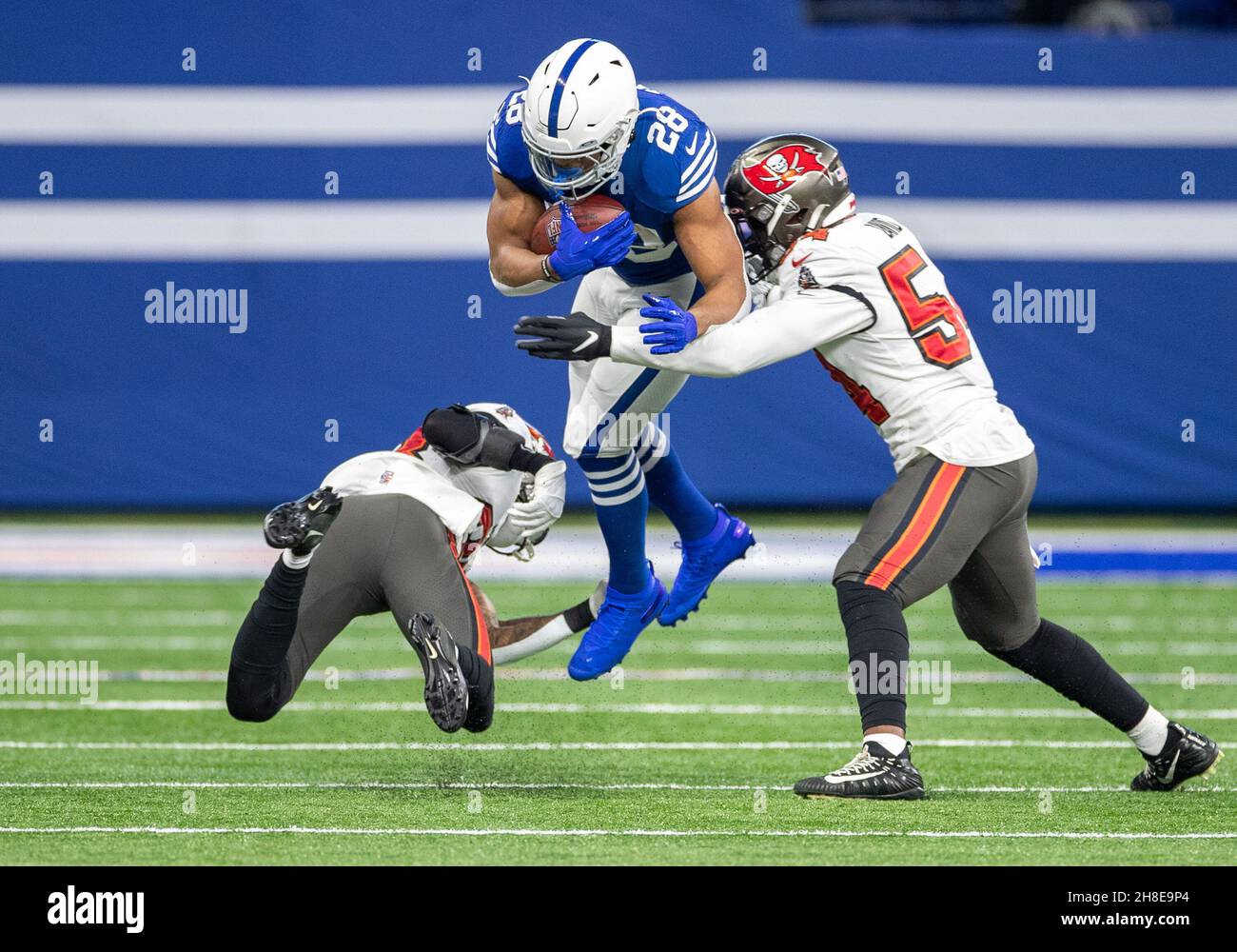 Indianapolis, Indiana, Stati Uniti. 28 novembre 2021. Gli Indianapolis Colts che running back Jonathan Taylor (28) corrono con la palla come Tampa Bay Buccaneers difensive back Sean Murphy-Bunting (23) e Tampa Bay Buccaneers linebacker Lavonte David (54) fanno l'attacco durante l'azione di gioco di football NFL tra i Tampa Bay Buccaneers e gli Indianapolis Colts al Lucas Oil Stadium in Indianapolis, Indiana. John Mersies/CSM/Alamy Live News Foto Stock