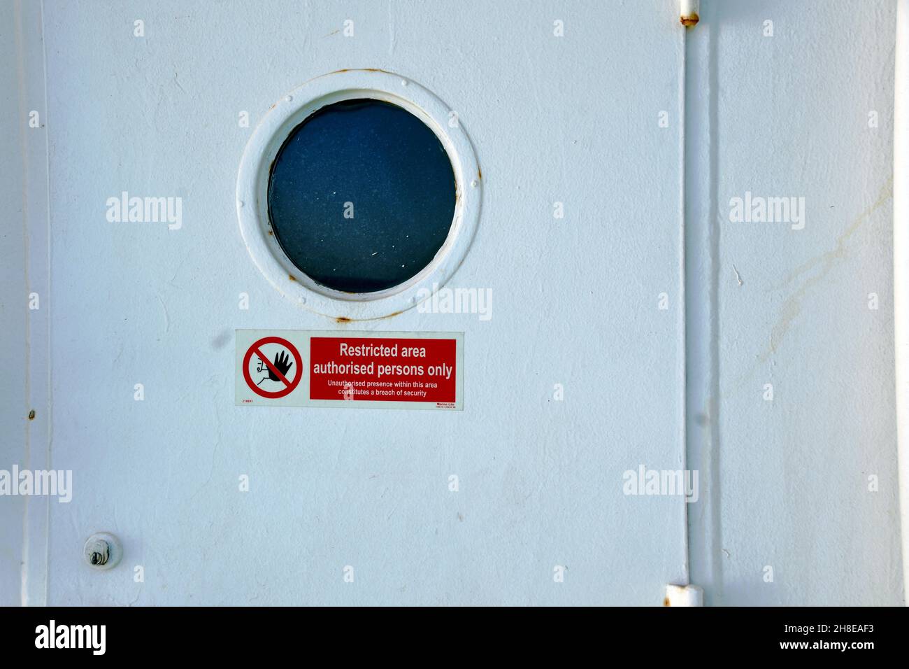 Porta di uscita in metallo bianco a tenuta stagna dalla sovrastruttura della nave mercantile di carico con spazio per la copia. Foto Stock