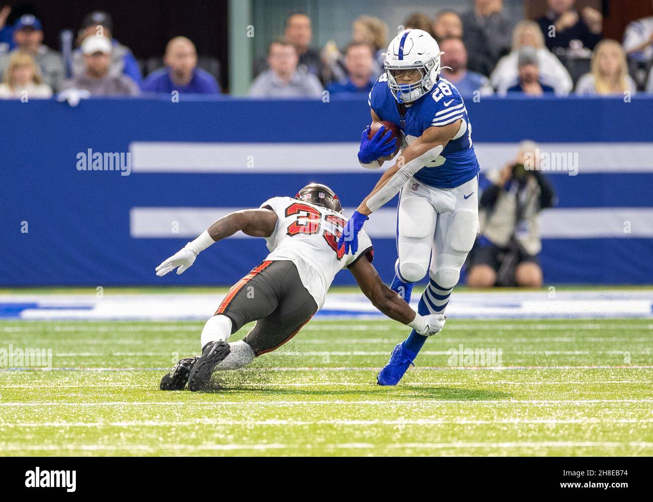 Indianapolis, Indiana, Stati Uniti. 28 novembre 2021. I Colts di Indianapolis che running back Jonathan Taylor (28) corre con la palla come Tampa Bay Buccaneers sicurezza Jordan Whitehead (33) percorre durante l'azione di gioco di football NFL tra i Tampa Bay Buccaneers e gli Indianapolis Colts al Lucas Oil Stadium di Indianapolis, Indiana. Tampa Bay sconfisse Indianapolis 38-31. John Mersies/CSM/Alamy Live News Foto Stock