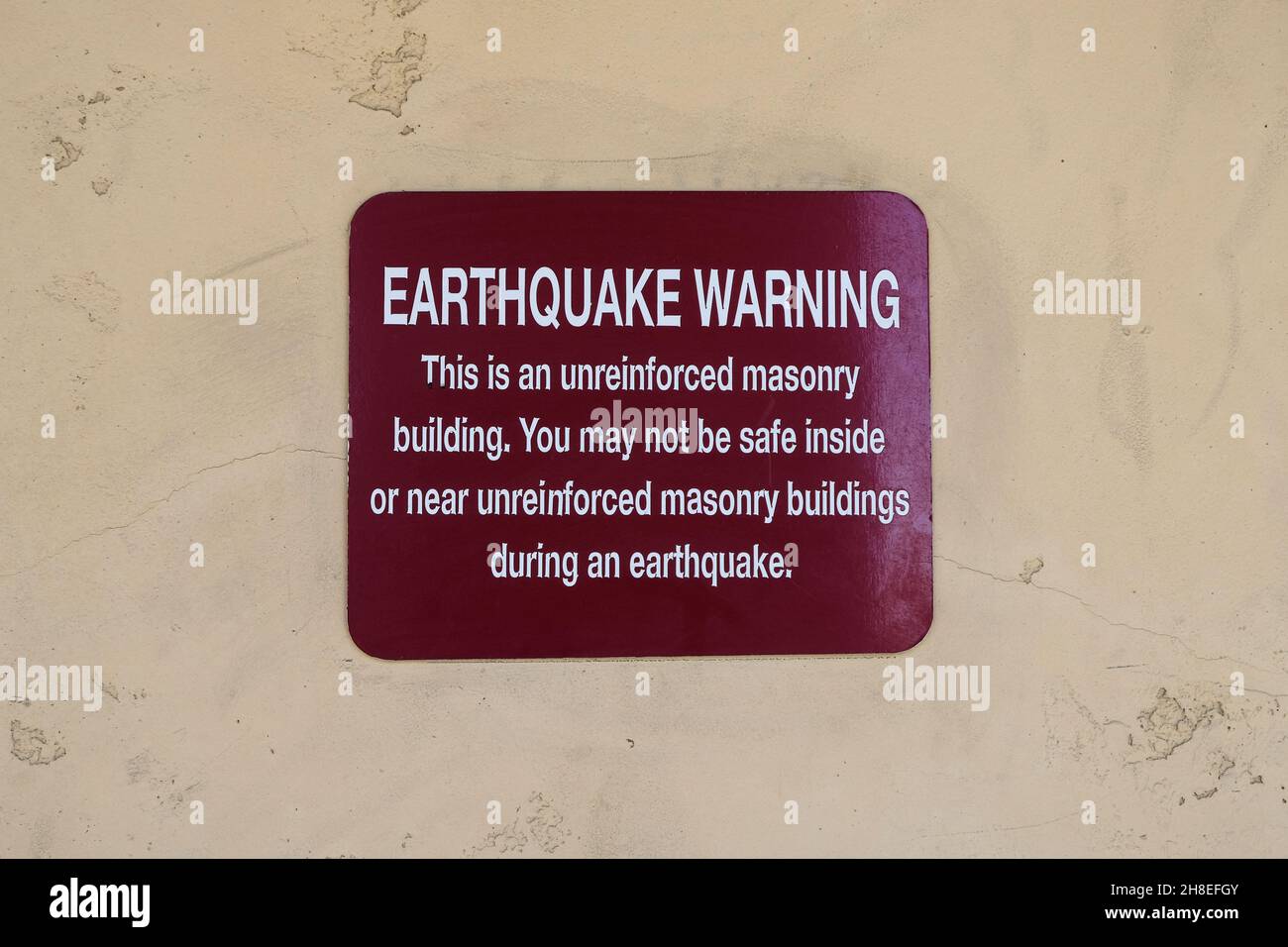 Segnale di avvertimento terremoto sulla parete esterna di un vecchio edificio a El Cajon, California, USA; muratura non rinforzata. Foto Stock