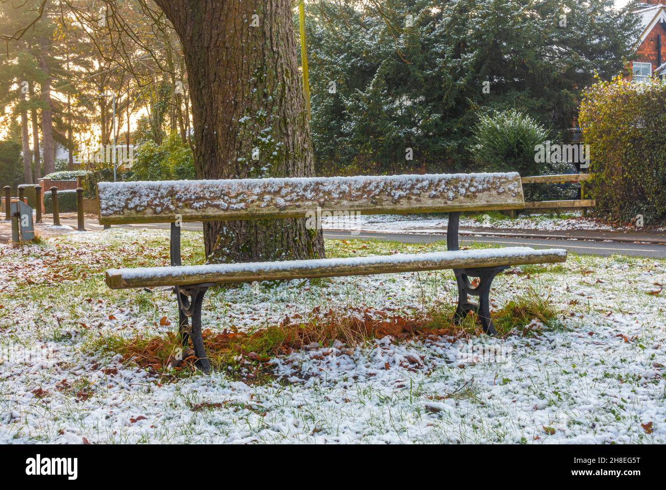 Una panca coperta di neve la mattina d'inverno dopo una leggera copertura di neve a Tilehurst, Reading, Regno Unito Foto Stock