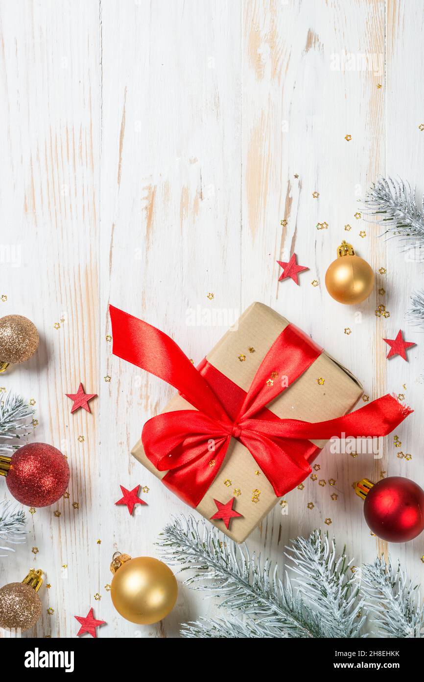 Scatola regalo di Natale con nastro rosso e decorazioni natalizie. Foto Stock