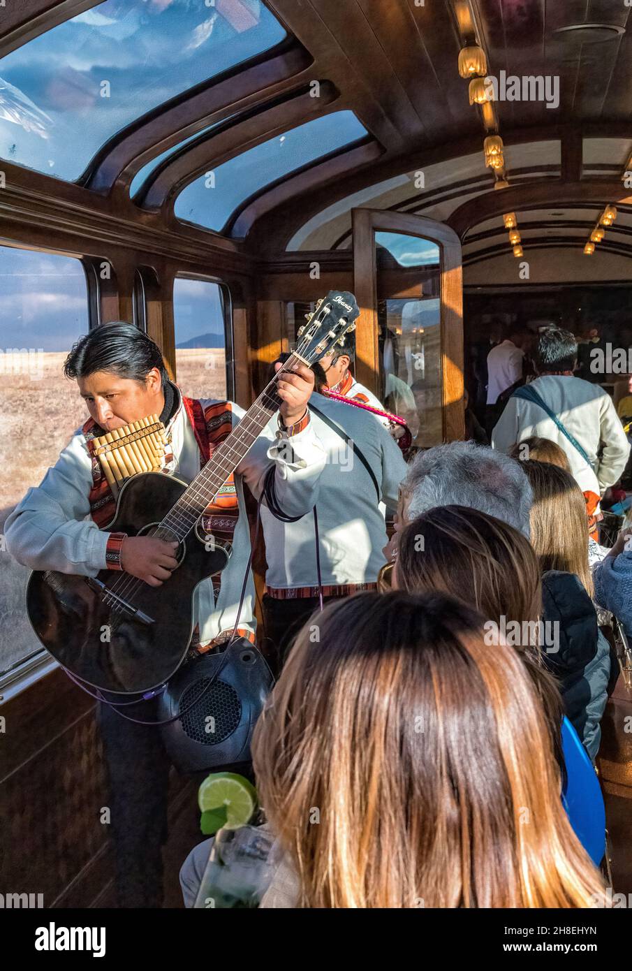 I passeggeri del treno esploratore andino, che corre tra Cusco e Puno, sono intrattenuti nella macchina di osservazione da musicisti e ballerini locali Foto Stock