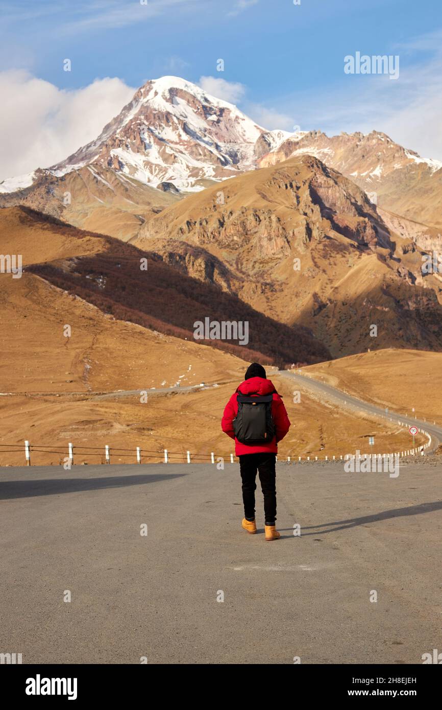 Vista posteriore del viaggiatore con zaino escursioni da solo in montagna regione Foto Stock