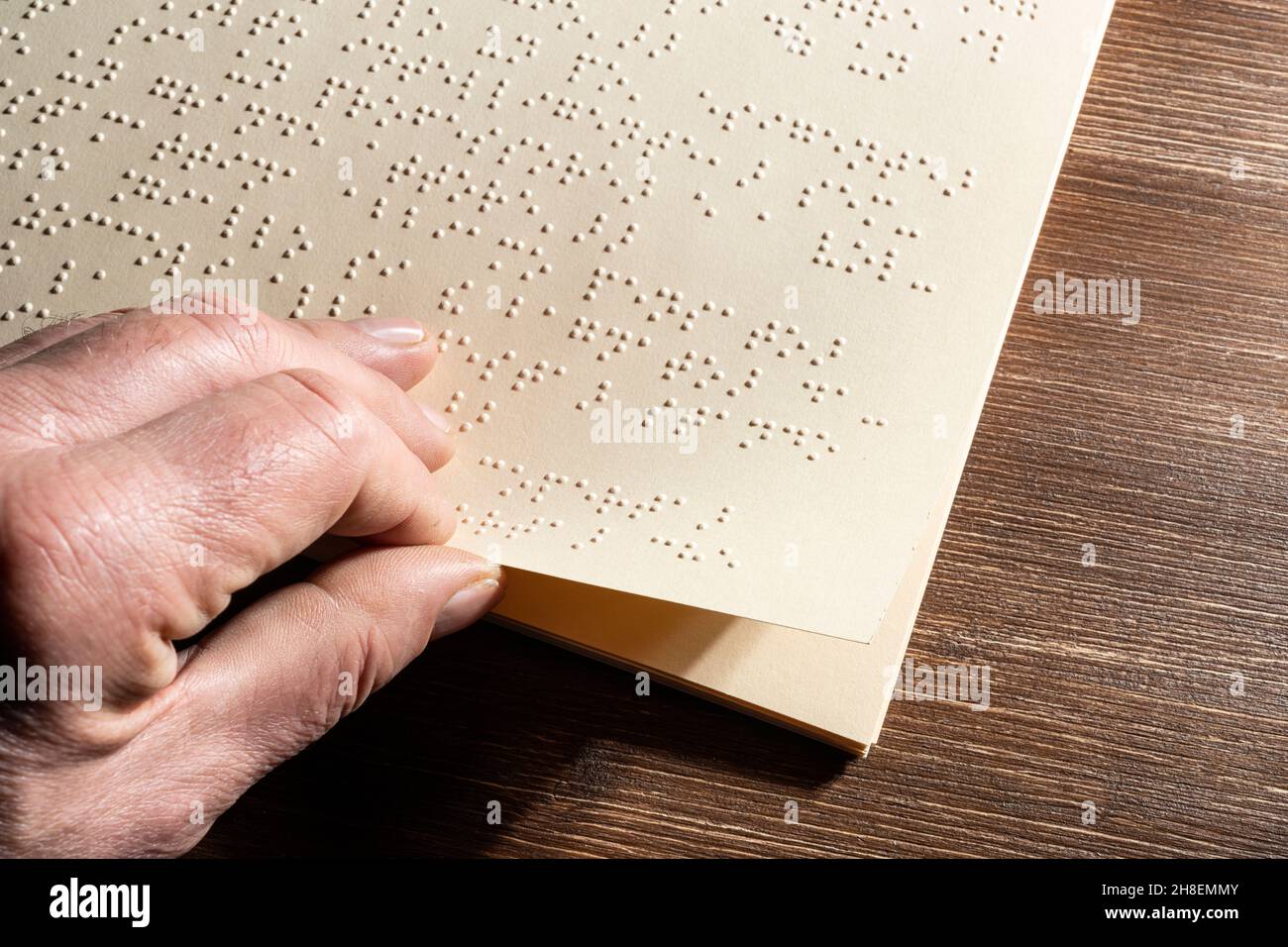 La pagina di un libro scritto nell'alfabeto Braille, il sistema di lettura tattile in rilievo per i non vedenti Foto Stock