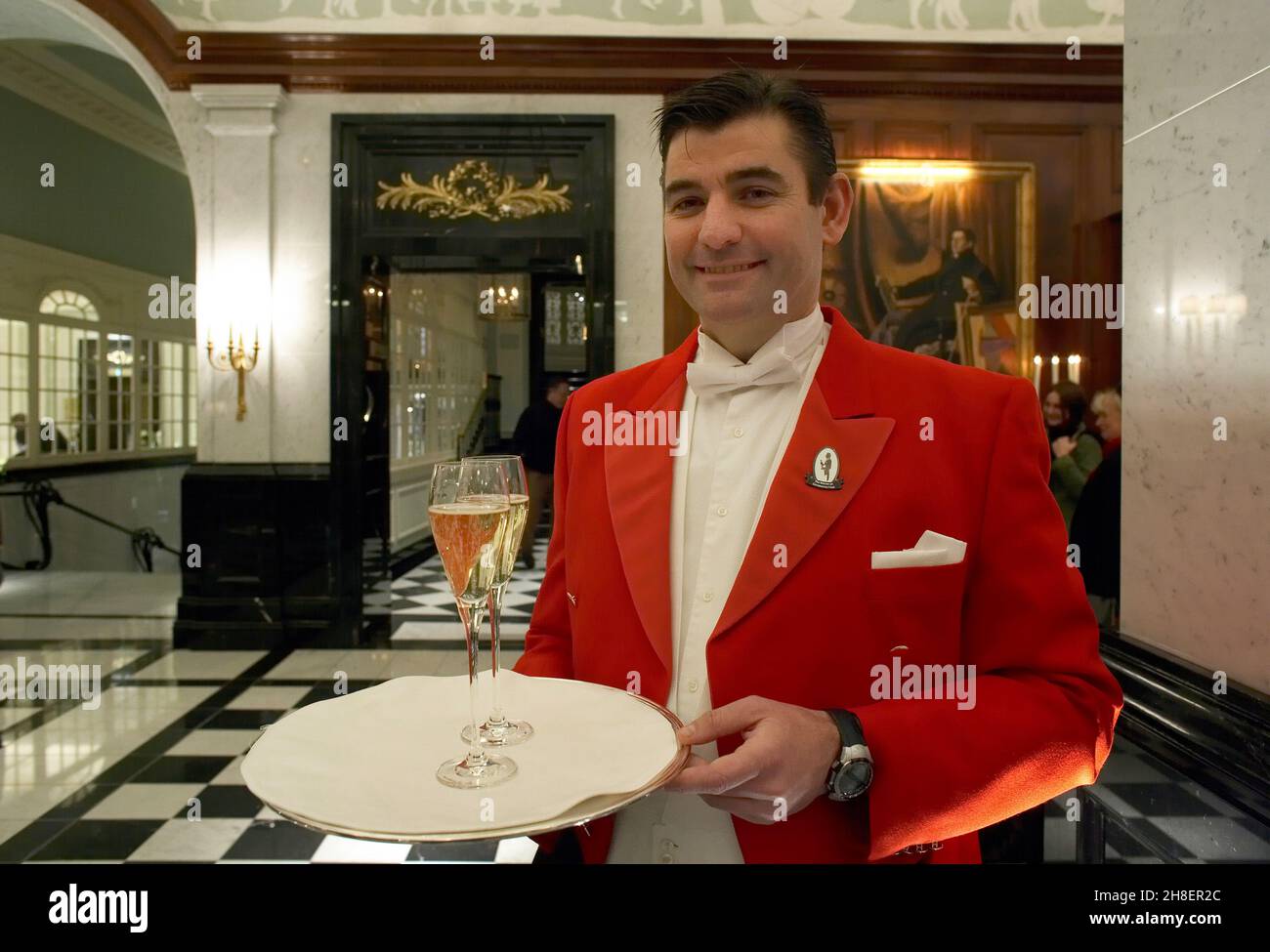 Il cameriere offre champagne agli ospiti del Savoy Hotel London / Foto Stock
