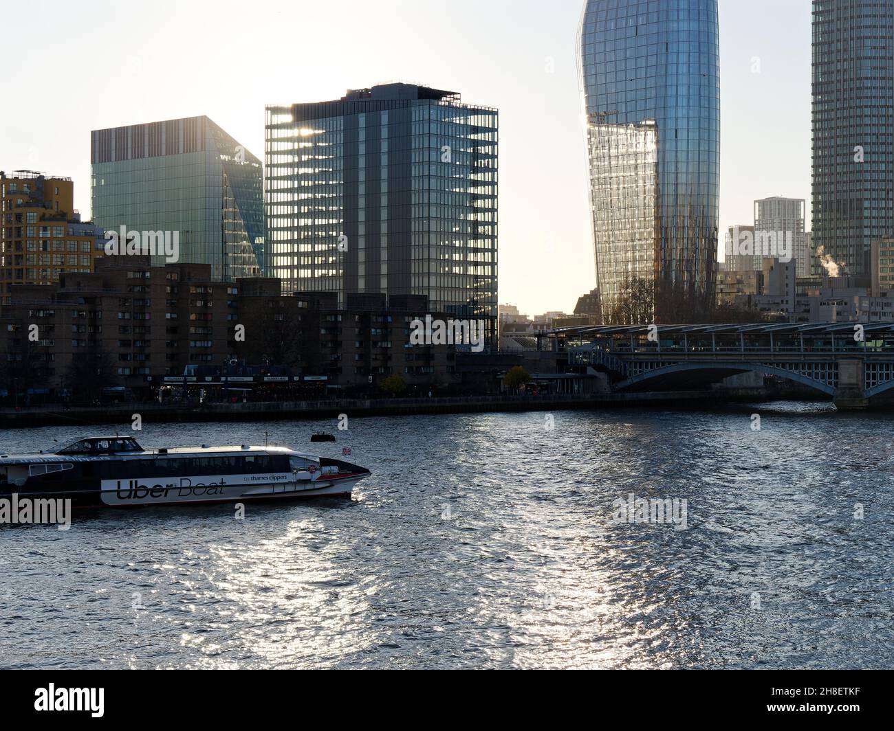 Londra, Greater London, Inghilterra, novembre 23 2021: Uber barca lungo il tamigi come la luce del sole brilla sull'acqua. Foto Stock