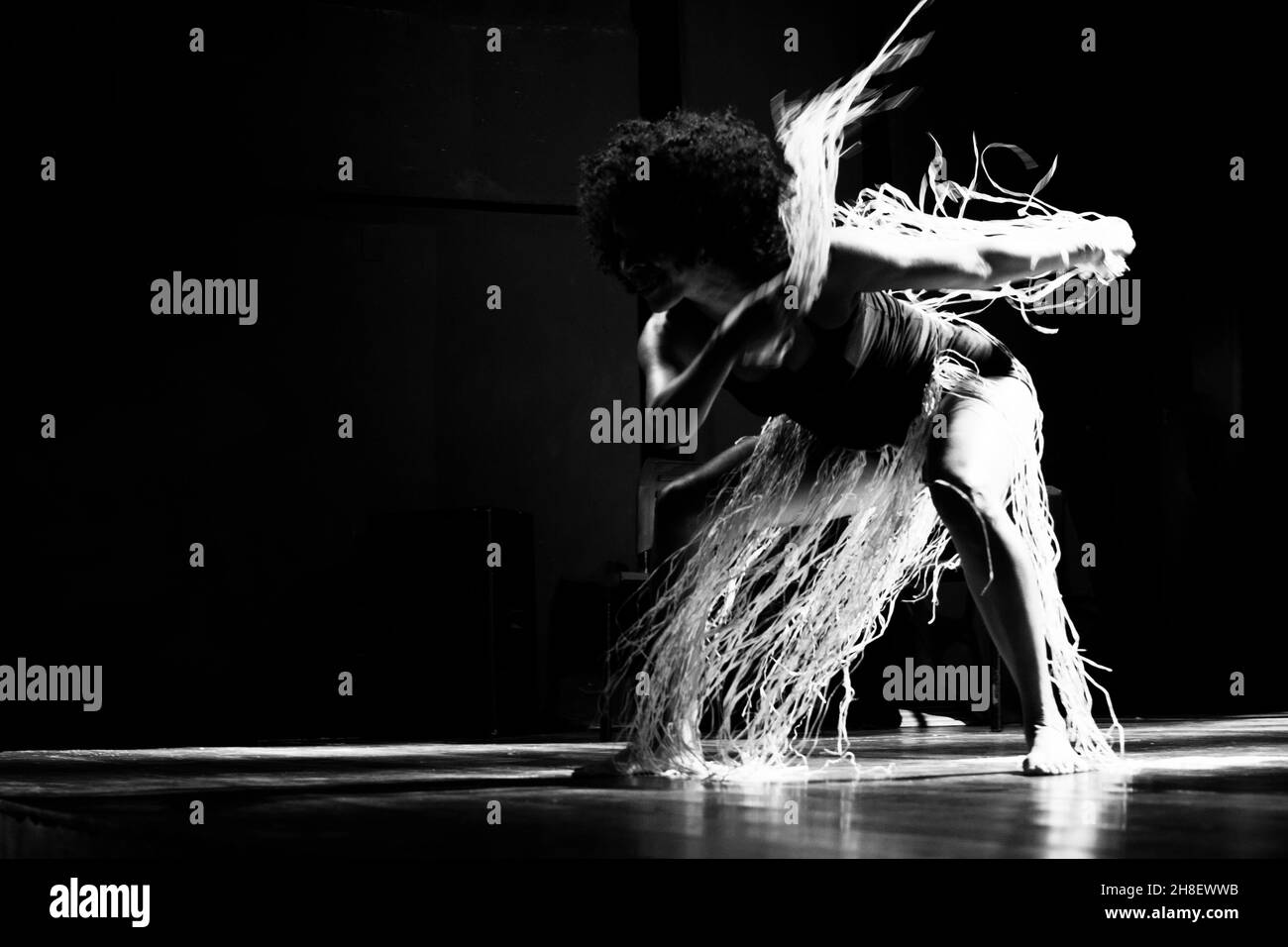 Ritratto in bianco e nero di una donna che balla sul palco su sfondo nero. Salvador, Bahia, Brasile. Foto Stock