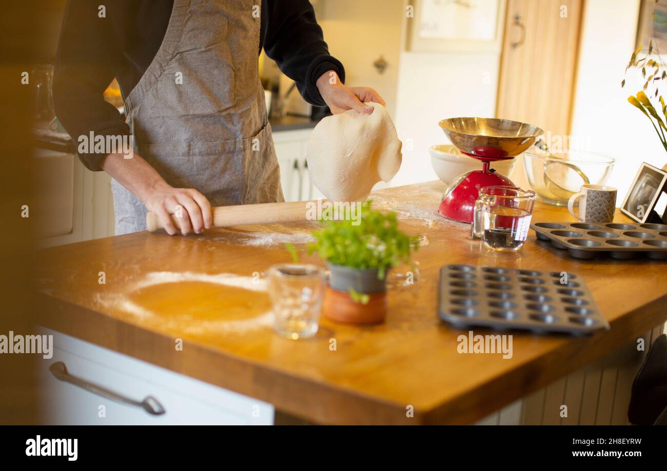 Uomo che fa pasta di pane fresco sul banco della cucina Foto Stock