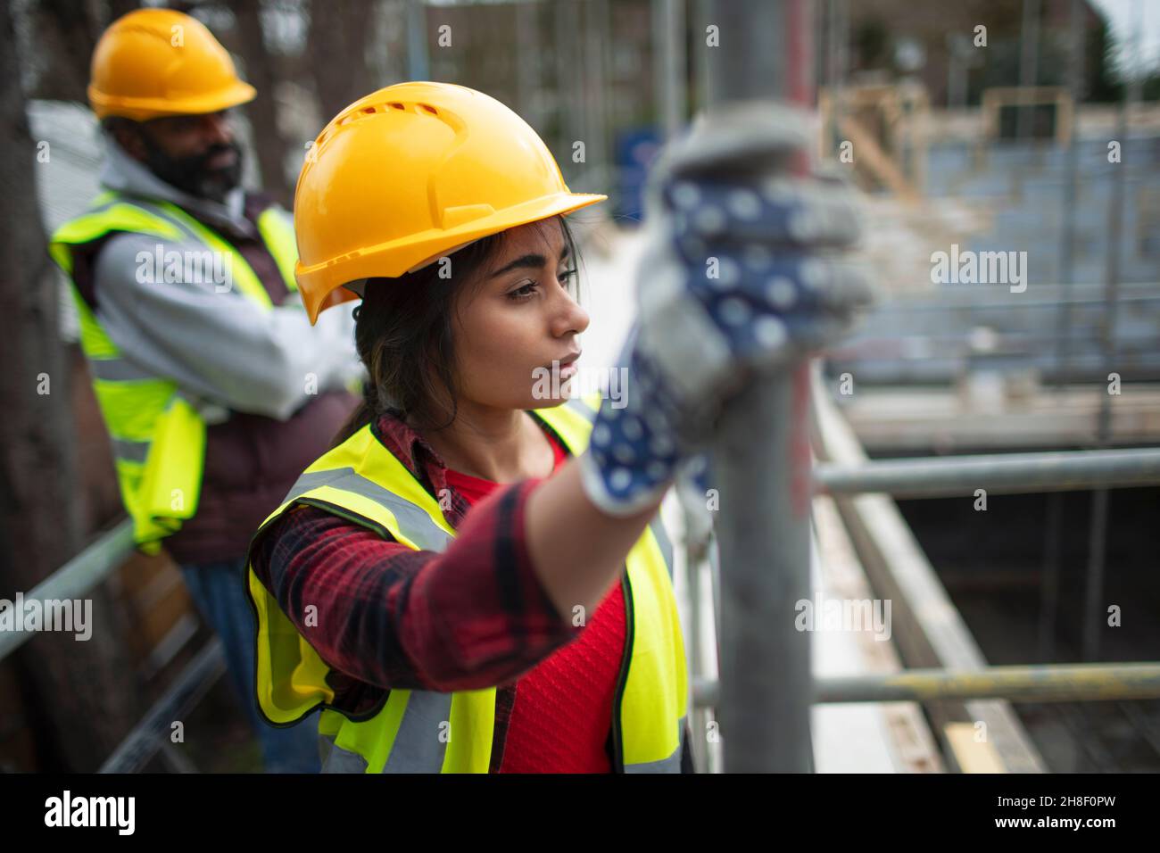 Pensieroso lavoratore di costruzione femminile in cantiere Foto Stock