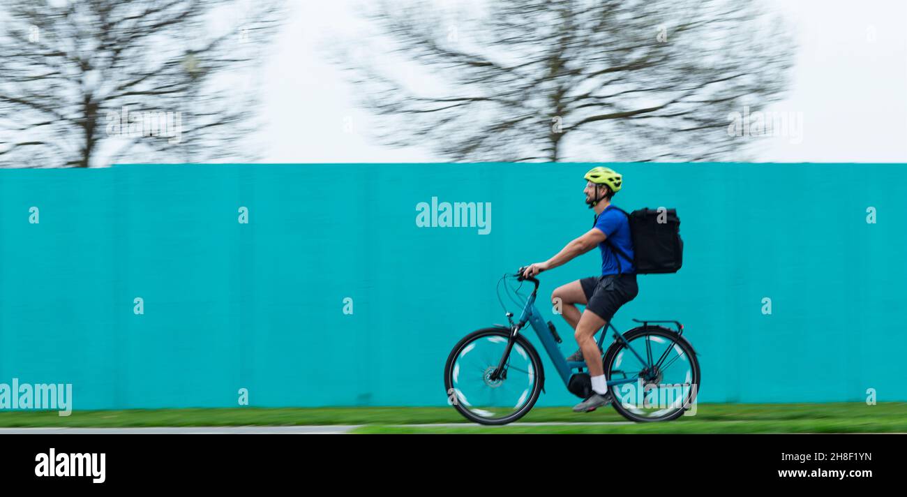 Corriere maschio che fa la consegna sulla bicicletta Foto Stock