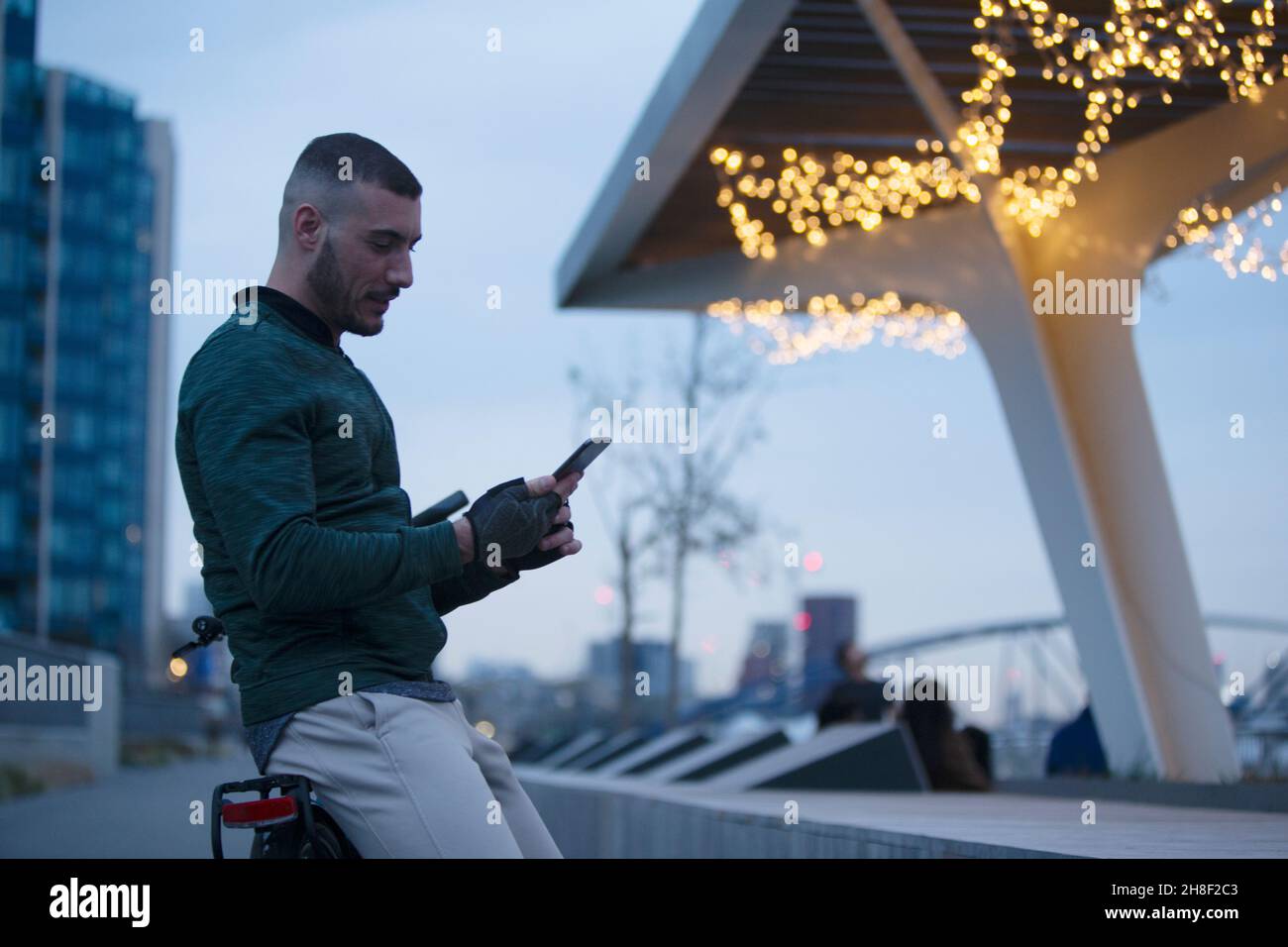 Uomo che utilizza lo smartphone in città di notte Foto Stock