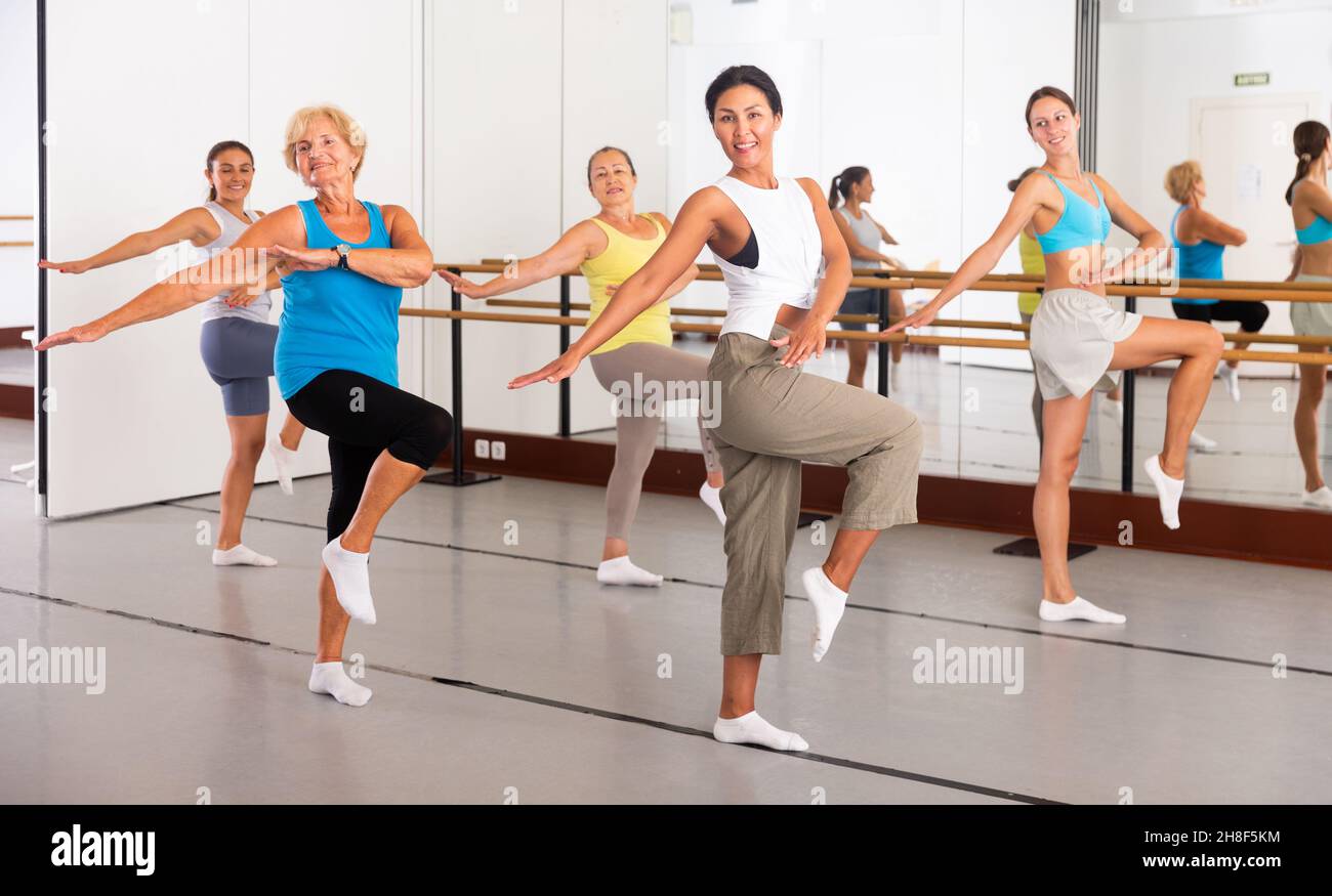 Gruppo di donne attive che praticano la danza energetica in uno studio Foto Stock Gruppo di donne attive che praticano la danza energetica in uno studio Foto Stock
