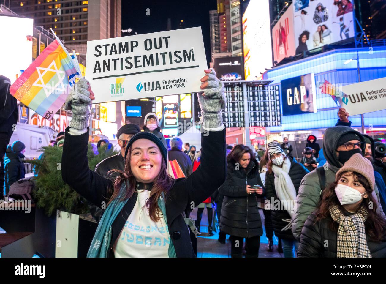 New York, Stati Uniti. 29 novembre 2021. La gente mostra i segni ebrei mentre assistono all'evento di illuminazione di Shine A Light on Antisemitism Menorah organizzato da una coalizione di oltre 60 organizzazioni e corporazioni ebraiche e non-ebraiche americane e canadesi il secondo giorno di Hannukkah nella Time Square di New York City. Credit: Enrique Shore/Alamy Live News Foto Stock