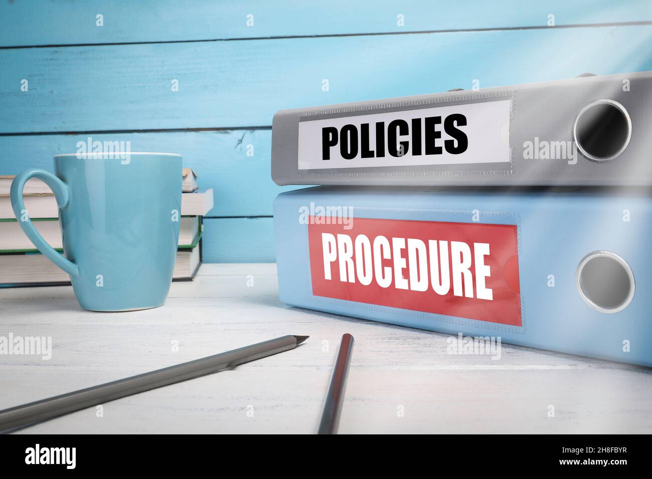 Politiche e procedure, concetto aziendale. Tazza da caffè, libri e documenti sul tavolo. Foto Stock