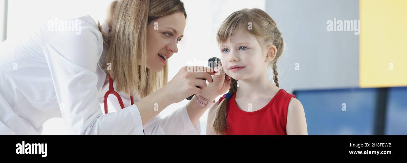 Il medico conduce l'esame medico dell'orecchio della bambina Foto Stock