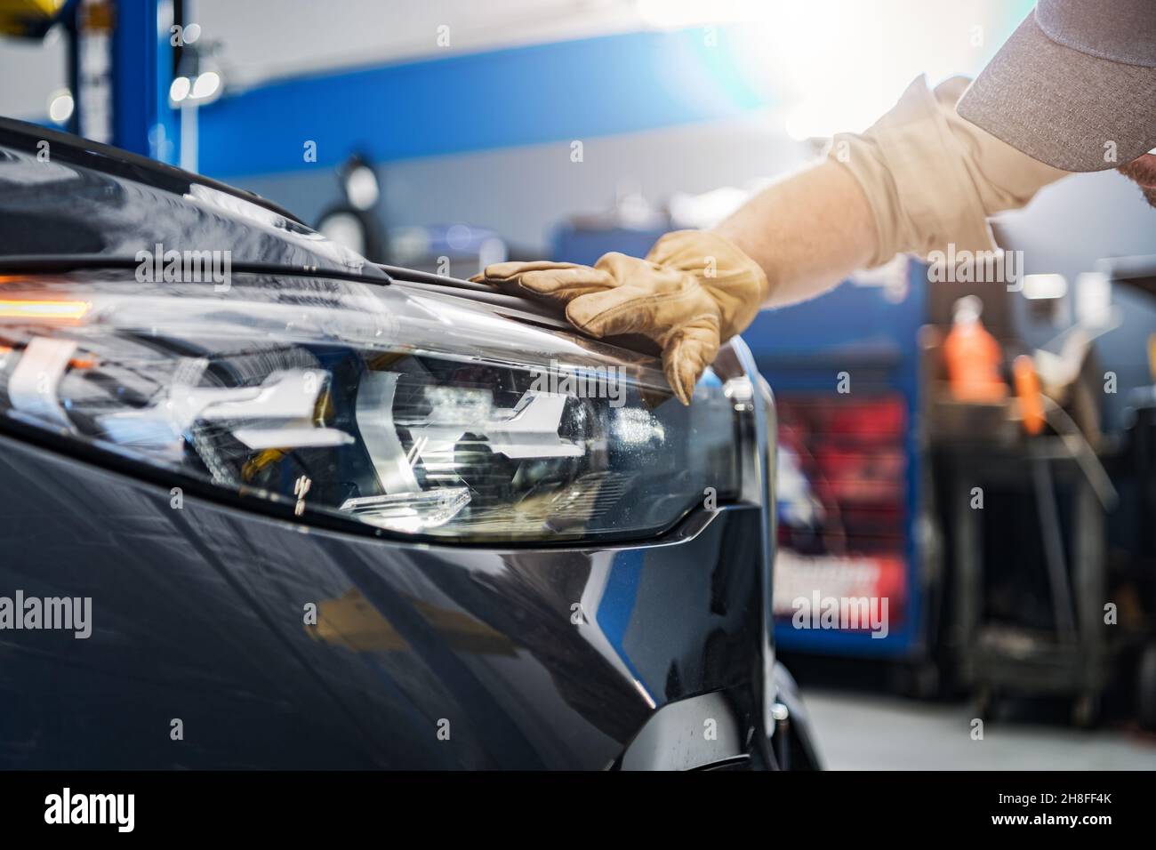 Controllo dei fari di un veicolo da parte del tecnico dell'assistenza automatica. Moderna illuminazione anteriore a LED per veicoli. Industria automobilistica e tecnologia. Foto Stock