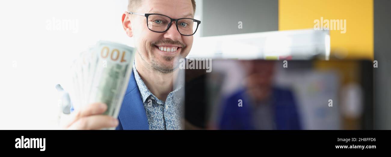Blogger sorridente dimostra denaro un centinaio di dollari bollette a macchina fotografica Foto Stock