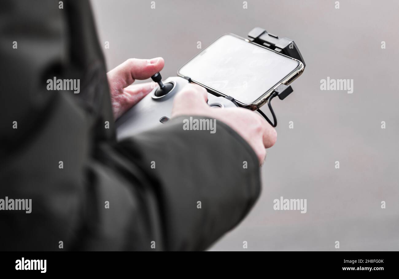 Operatore drone moderno con App Controller per smartphone Close Up. Foto Stock