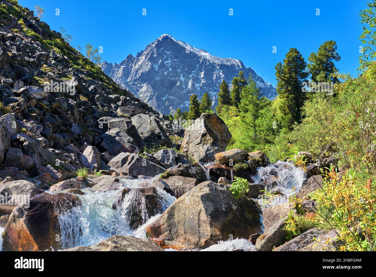 Paesaggio alpino con una cascata d'acqua su un torrente di montagna. Montagne Sayan orientali. Buryatia Foto Stock