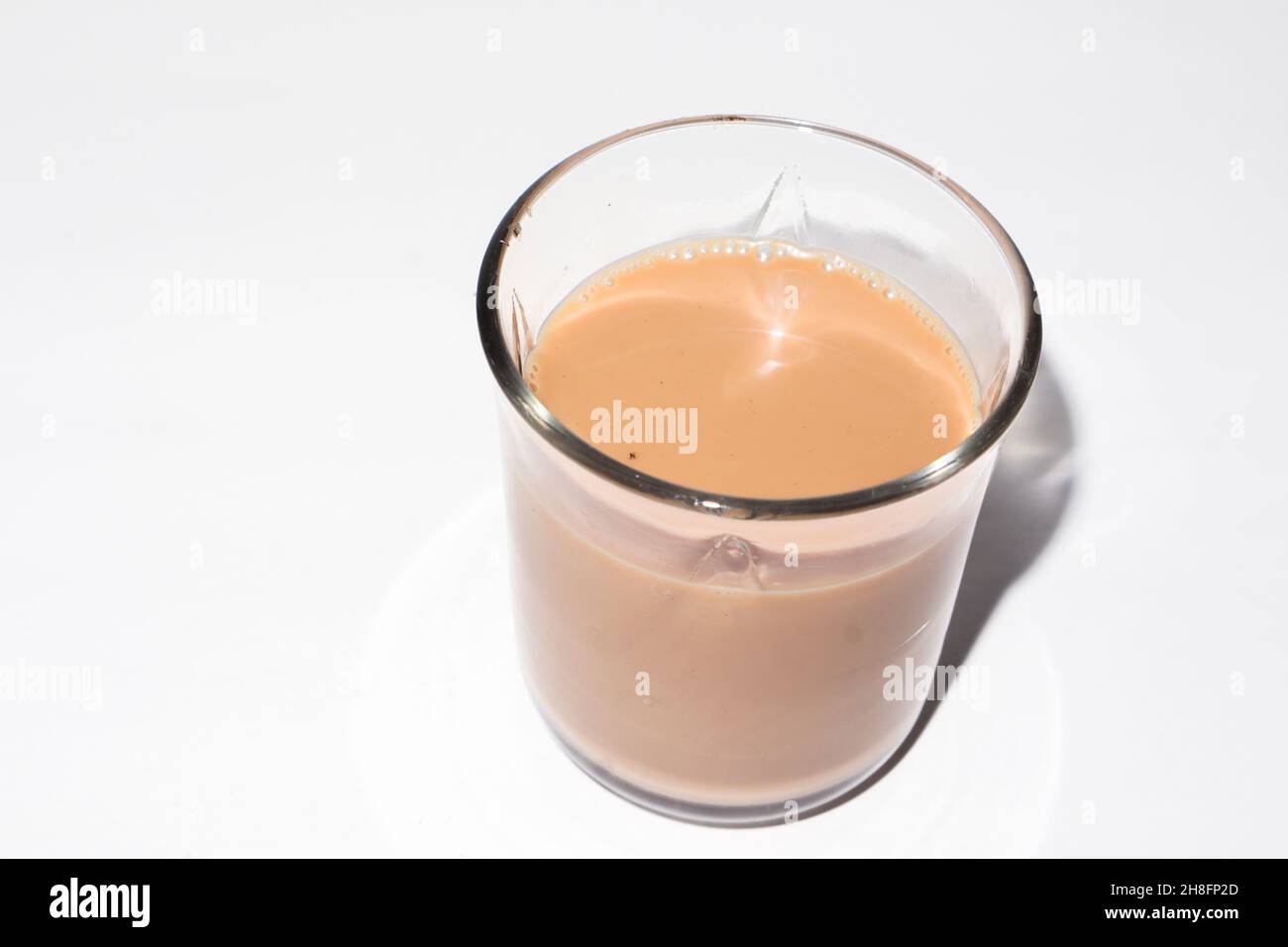 Tazza di vetro di tè caldo allo zenzero isolato su sfondo bianco. Foto Stock