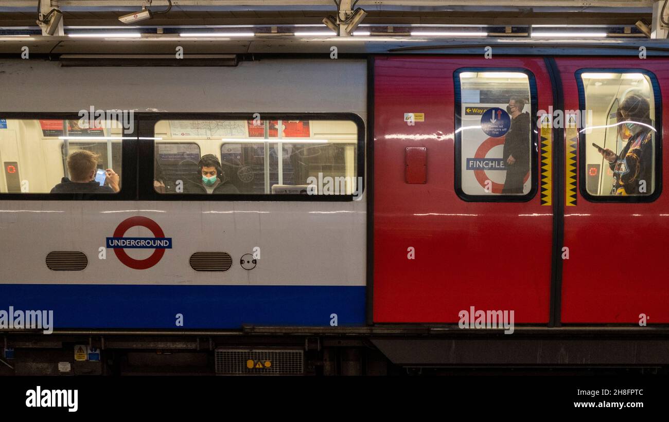 Londra, Regno Unito. 30 novembre 2021. Le persone viaggiano in metropolitana durante l'ora di punta. Le coperture facciali sono ora obbligatorie per i viaggi sui trasporti pubblici, e in luoghi pubblici specifici dopo che il governo britannico ha annunciato nuove misure per frenare la diffusione del coronavirus nel Regno Unito in risposta ai casi in cui la nuova variante Omicron è stata rilevata nel paese. Credit: Stephen Chung / Alamy Live News Foto Stock