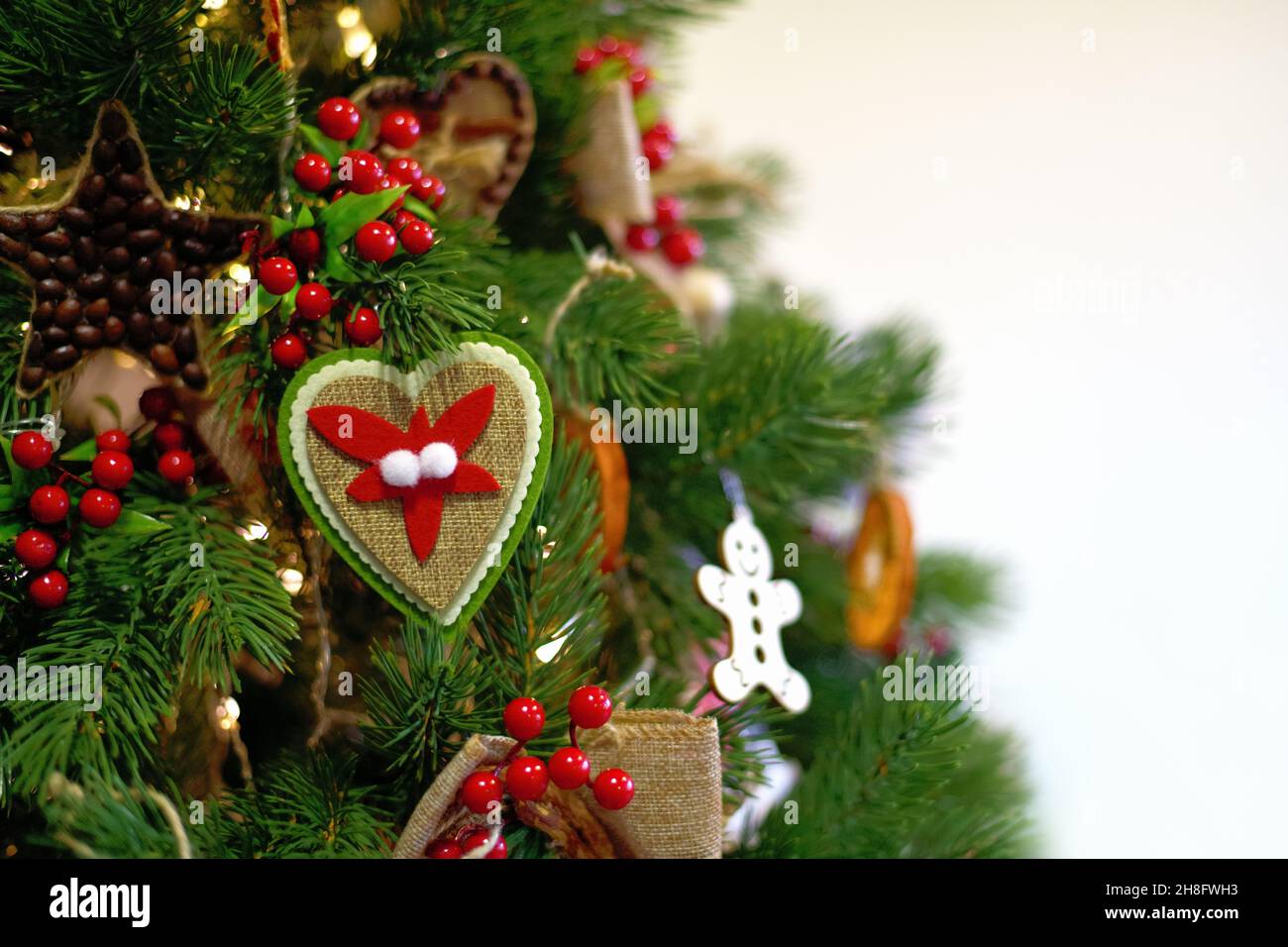 Albero di Natale. Anno nuovo. Albero di Natale decorato in verde con giocattoli di Natale su sfondo bianco Foto Stock