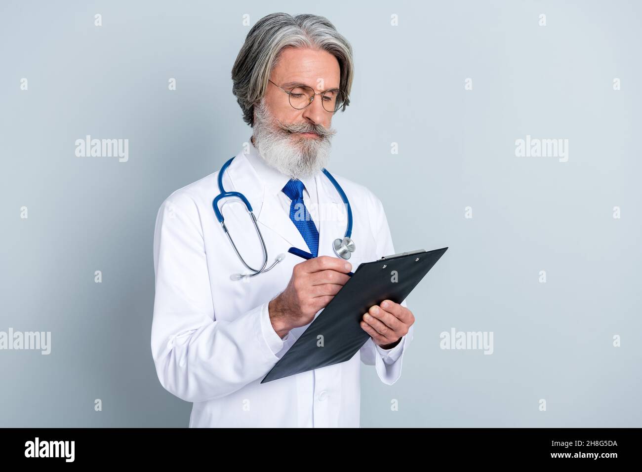 Foto di intelligente sicuro maschio maturo medico indossare bianco cappotto occhiali firma assicurazione spazio vuoto isolato grigio sfondo di colore Foto Stock
