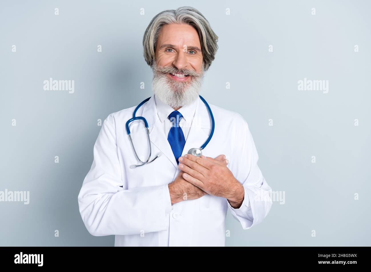 Foto di esperto doc uomo mettere mano cuore giuramento ippocratico proteggere infarto anziani paziente isolato su sfondo grigio colore Foto Stock