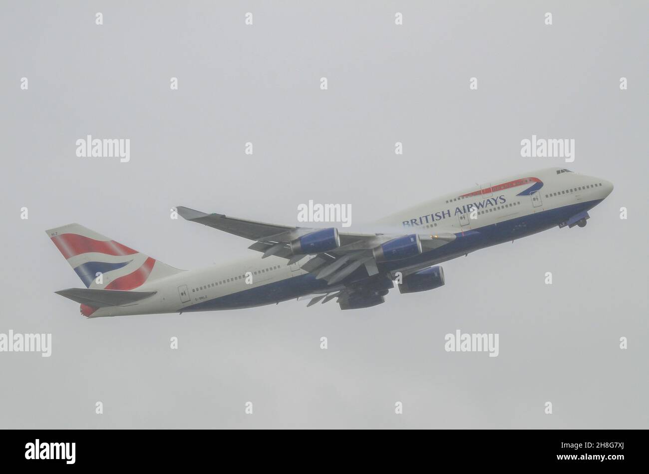 British Airways Boeing 747 Jumbo Jet Airliner Jet aereo jet G-BNLZ decollo dall'aeroporto di Londra Heathrow in forte nube e nebbia con condensa Foto Stock