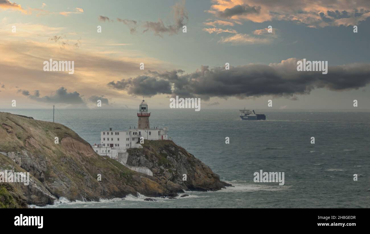 Baily Lighthouse, la penisola di Howth Head in giorno soleggiato e nuvoloso, Seashore, scogliere e rocce, paesaggio, Dublino, L'Irlanda, Foto Stock