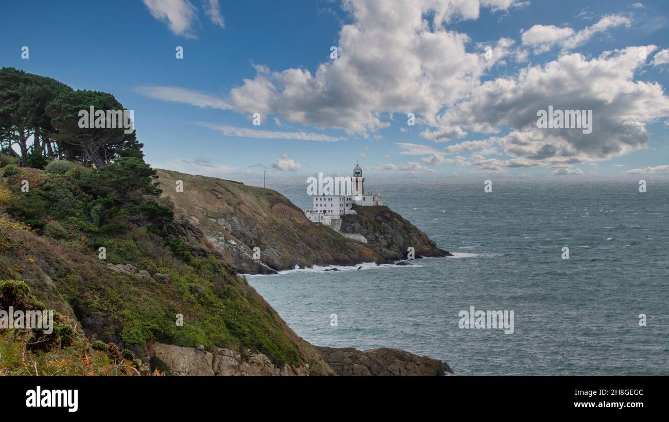 Baily Lighthouse, la penisola di Howth Head in giorno soleggiato e nuvoloso, Seashore, scogliere e rocce, paesaggio, Dublino, L'Irlanda, Foto Stock