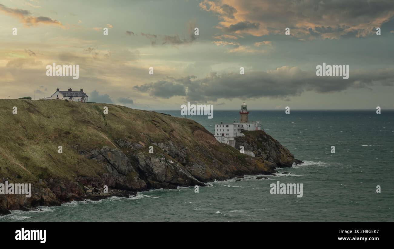 Baily Lighthouse, la penisola di Howth Head in giorno soleggiato e nuvoloso, Seashore, scogliere e rocce, paesaggio, Dublino, L'Irlanda, Foto Stock