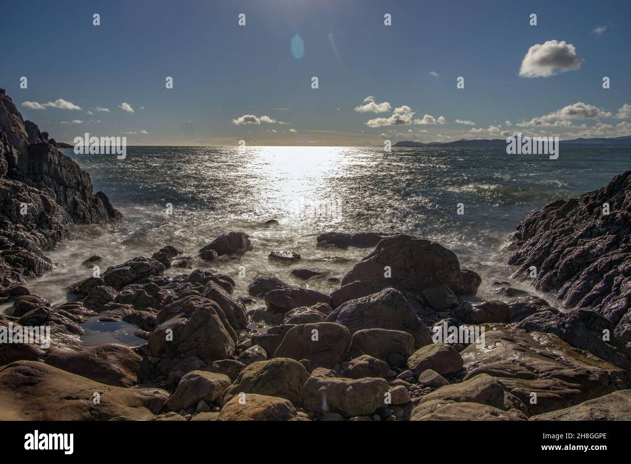 La penisola di Howth Head in giornata soleggiata e nuvolosa, esposizione a lungo, Dublino County, Seashore di scogliere, baie e rocce paesaggio, Irlanda Foto Stock
