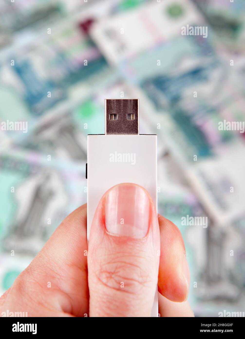 Unità flash USB nella mano sul background della valuta russa Foto Stock