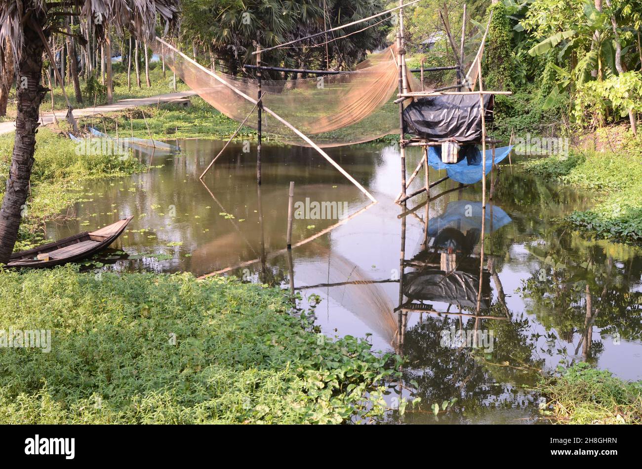 Bei villaggi di Bengala, corpi d'acqua, palme, palme da datteri, reti da pesca, barche da pesca Foto Stock