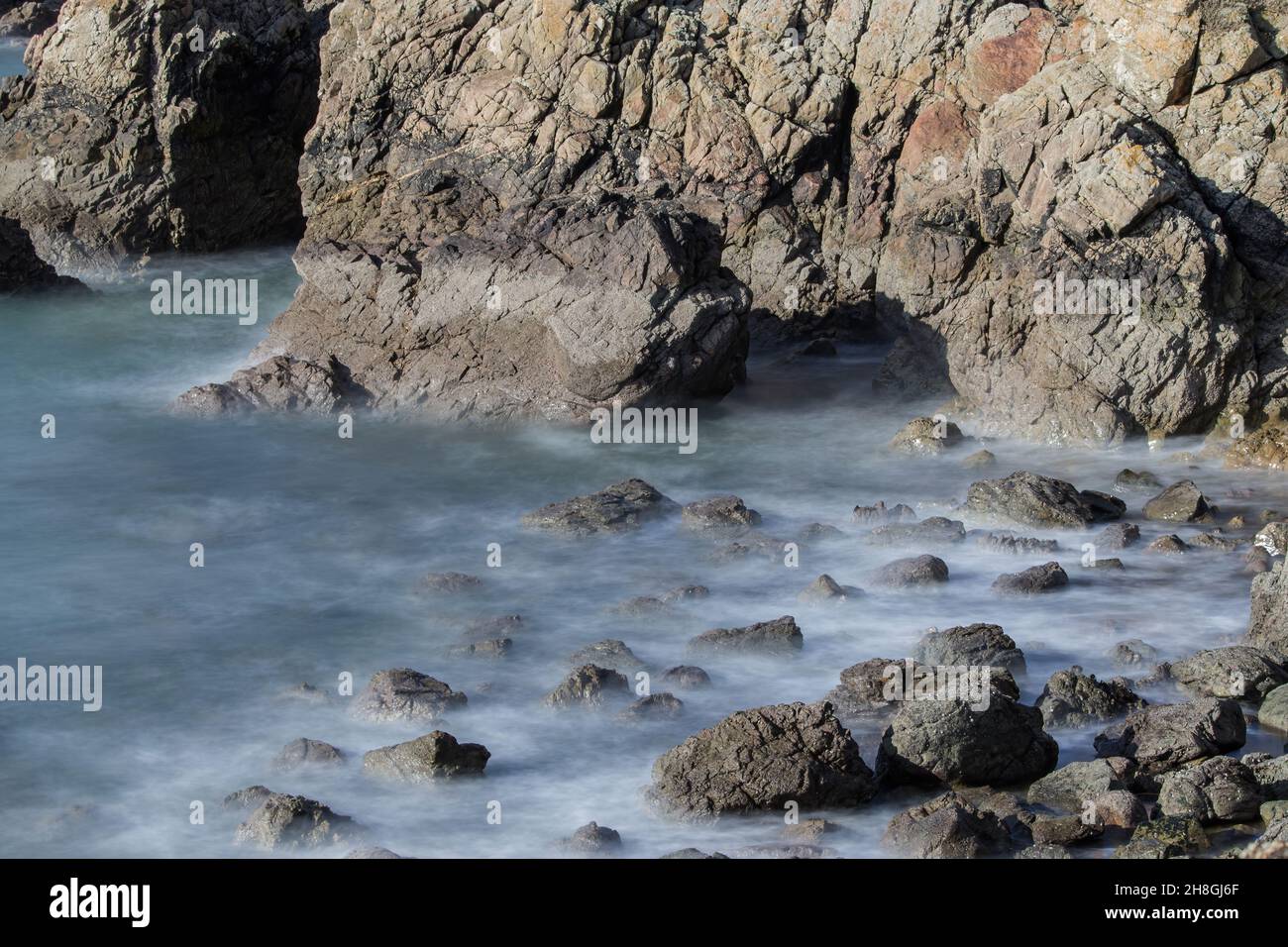 La penisola di Howth Head in giornata soleggiata e nuvolosa, esposizione a lungo, Dublino County, Seashore di scogliere, baie e rocce paesaggio, Irlanda Foto Stock