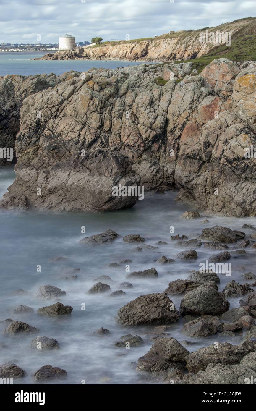 La penisola di Howth Head in giornata soleggiata e nuvolosa, esposizione a lungo, Dublino County, Seashore di scogliere, baie e rocce paesaggio, Irlanda Foto Stock