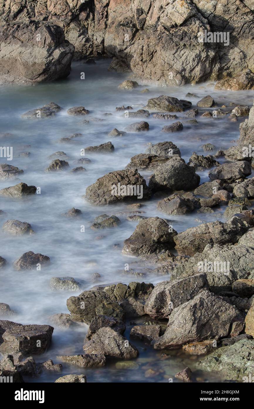 La penisola di Howth Head in giornata soleggiata e nuvolosa, esposizione a lungo, Dublino County, Seashore di scogliere, baie e rocce paesaggio, Irlanda Foto Stock