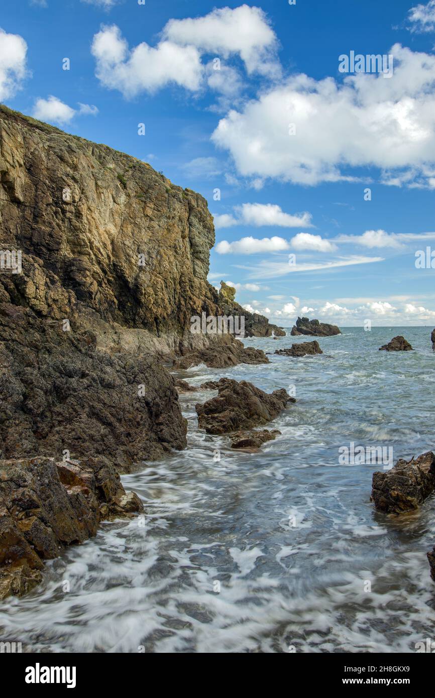 La penisola di Howth Head in giornata soleggiata e nuvolosa, baia nascosta, cielo drammatico, contea di Dublino, Seashore di scogliere, Baie e rocce paesaggio, Irlanda Foto Stock