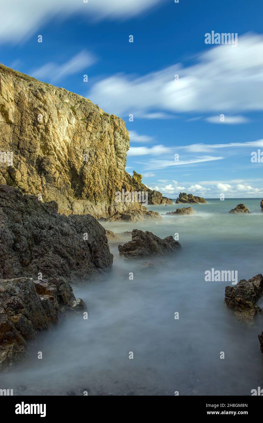 La penisola di Howth Head in giornata soleggiata e nuvolosa, esposizione a lungo, Dublino County, Seashore di scogliere, baie e rocce paesaggio, Irlanda Foto Stock