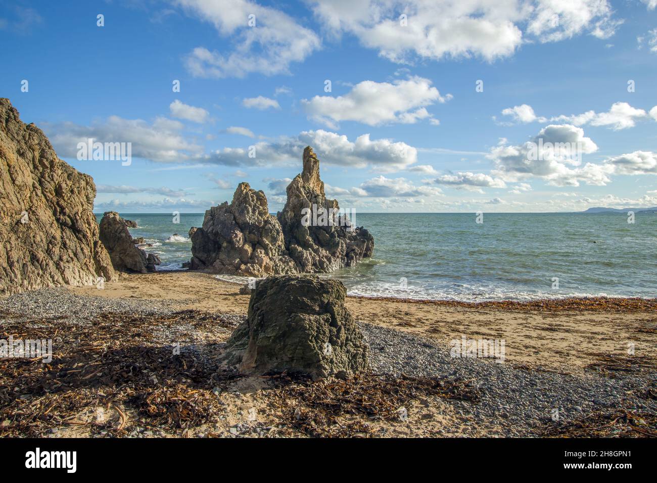La penisola di Howth Head in giornata soleggiata e nuvolosa, baia nascosta, cielo drammatico, contea di Dublino, Seashore di scogliere, Baie e rocce paesaggio, Irlanda Foto Stock