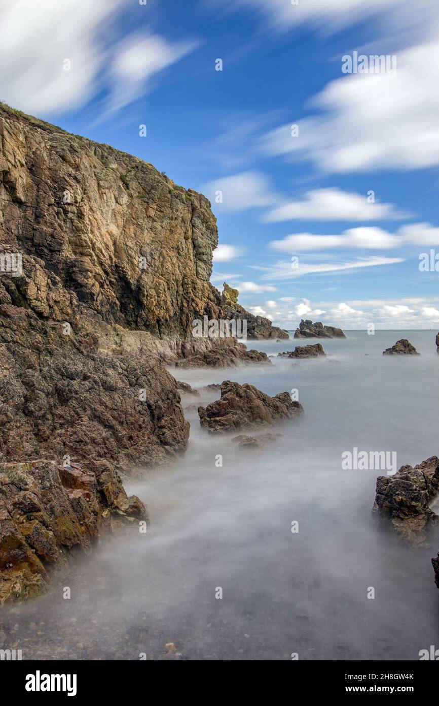 La penisola di Howth Head in giornata soleggiata e nuvolosa, esposizione a lungo, Dublino County, Seashore di scogliere, baie e rocce paesaggio, Irlanda Foto Stock