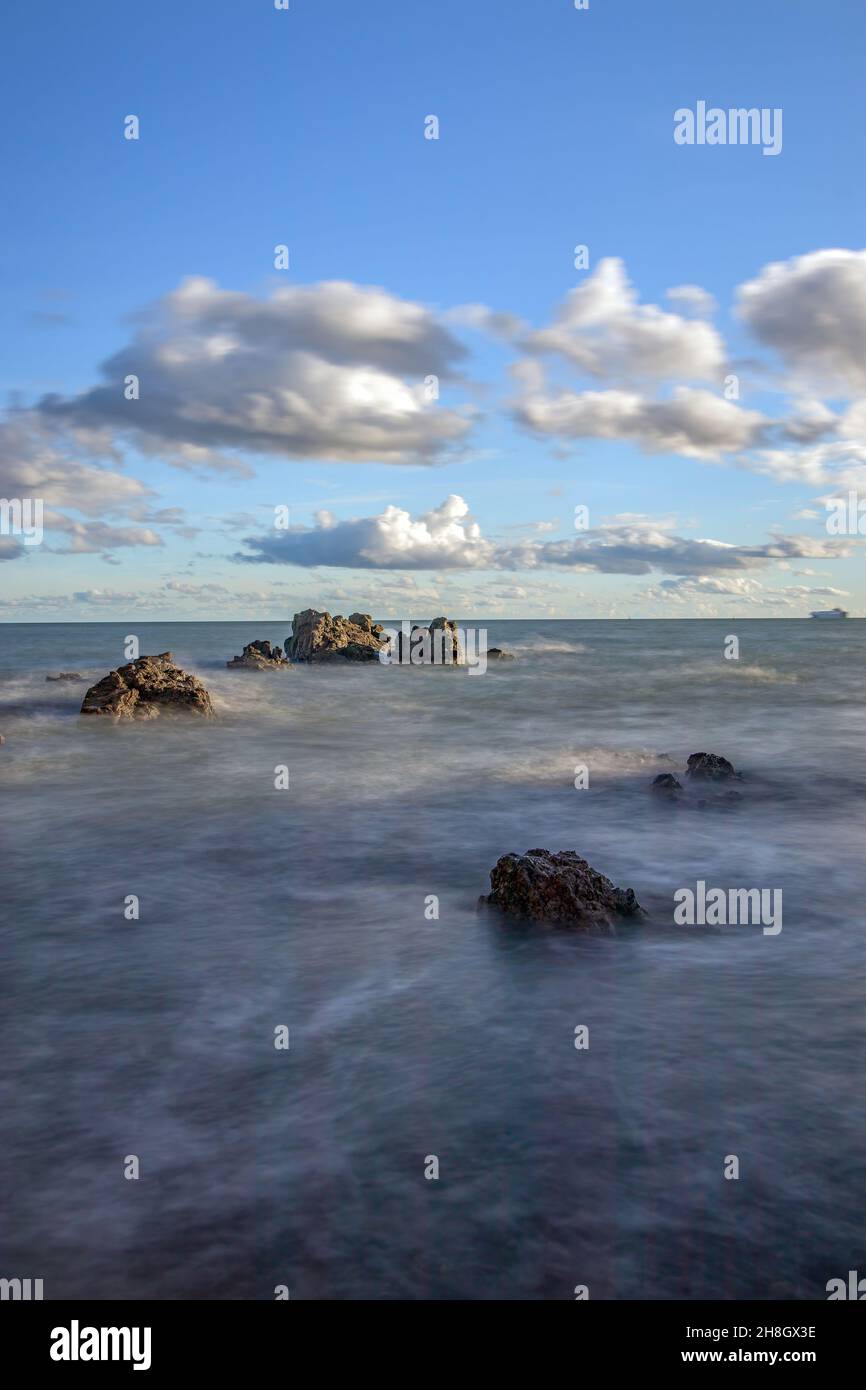 La penisola di Howth Head in giornata soleggiata e nuvolosa, esposizione a lungo, Dublino County, Seashore di scogliere, baie e rocce paesaggio, Irlanda Foto Stock