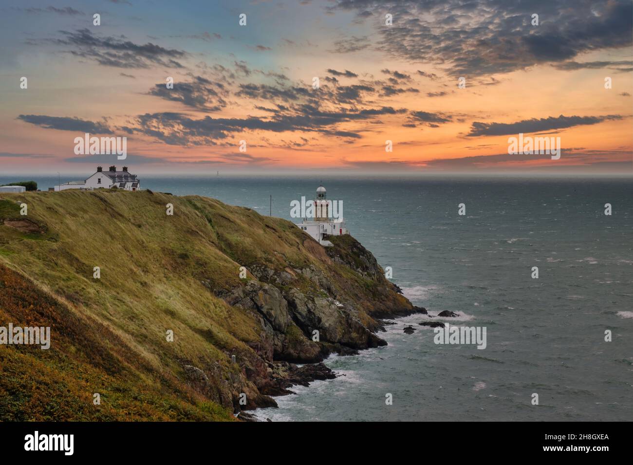 Baily Lighthouse, la penisola di Howth Head in giorno soleggiato e nuvoloso, Seashore, scogliere e rocce, paesaggio, Dublino, L'Irlanda, Foto Stock