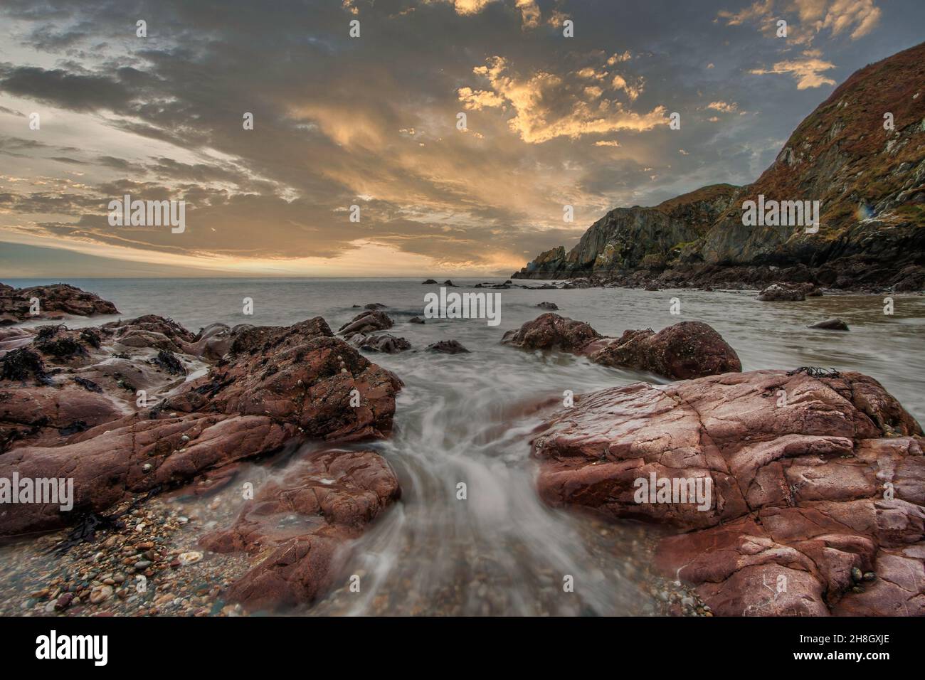 La penisola di Howth Head in giornata soleggiata e nuvolosa, esposizione a lungo, Dublino County, Seashore di scogliere, baie e rocce paesaggio, Irlanda Foto Stock