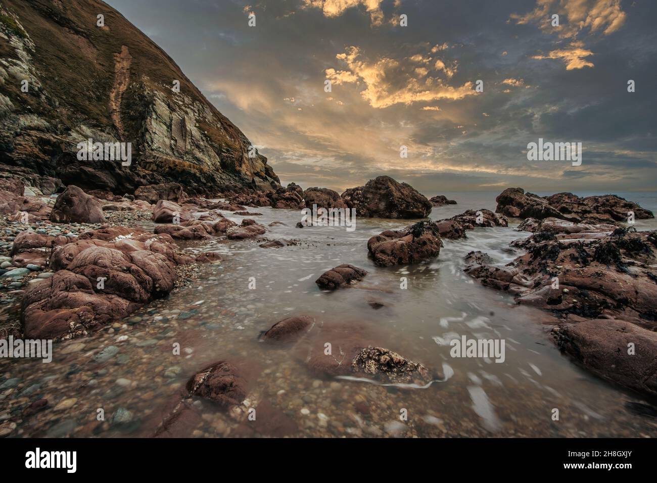 La penisola di Howth Head in giornata soleggiata e nuvolosa, esposizione a lungo, Dublino County, Seashore di scogliere, baie e rocce paesaggio, Irlanda Foto Stock