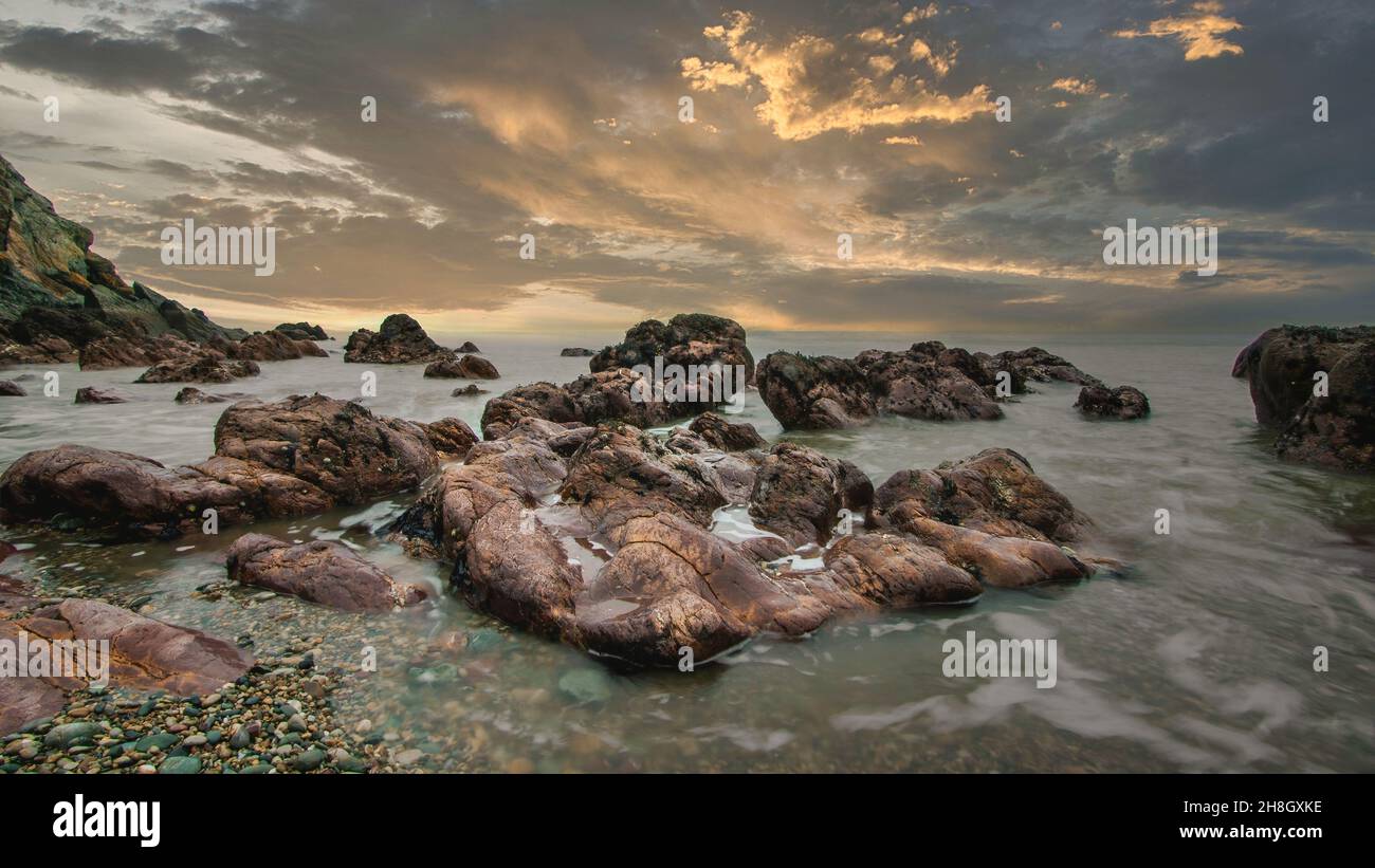 La penisola di Howth Head in giornata soleggiata e nuvolosa, esposizione a lungo, Dublino County, Seashore di scogliere, baie e rocce paesaggio, Irlanda Foto Stock