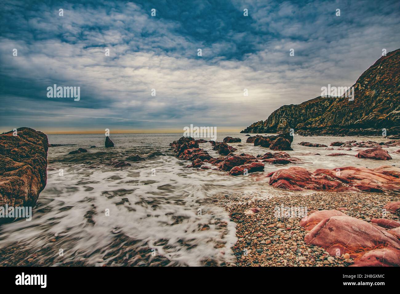La penisola di Howth Head in giornata soleggiata e nuvolosa, esposizione a lungo, Dublino County, Seashore di scogliere, baie e rocce paesaggio, Irlanda Foto Stock