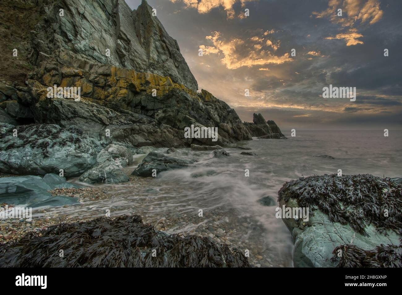 La penisola di Howth Head in giornata soleggiata e nuvolosa, esposizione a lungo, Dublino County, Seashore di scogliere, baie e rocce paesaggio, Irlanda Foto Stock